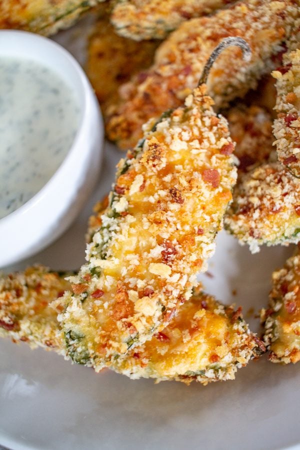 Baked Jalapeño Poppers are filled with cream cheese, cheddar cheese, and Monterey jack cheese, coated in a crispy breadcrumb coating and baked. It's a slightly healthier take on the popular appetizer.