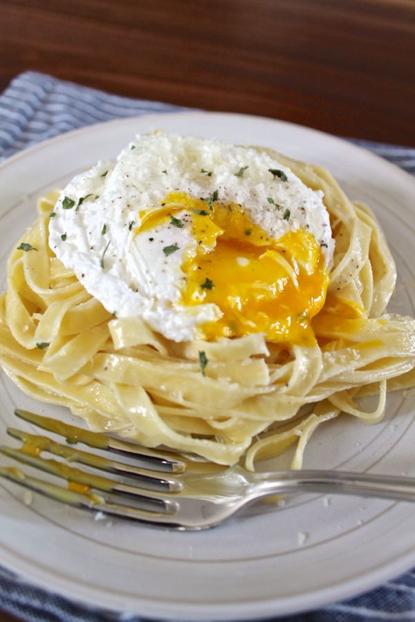 Cream Parmesan Pasta with a Poached Egg Recipe - I've found the ultimate brunch for the person who tends to prefer the lunch side of brunch. Inspired by a dish from Nellcote's old brunch menu, I created Creamy Parmesan Pasta with a Poached Egg. It's fresh pasta tossed in a parmesan cream sauce with a touch of lemon, topped with a runny poached egg. This is a sophisticated meal that takes just 15 minutes to prepare. While I think it is a perfect Sunday brunch, it would make a quick weeknight dinner too.
