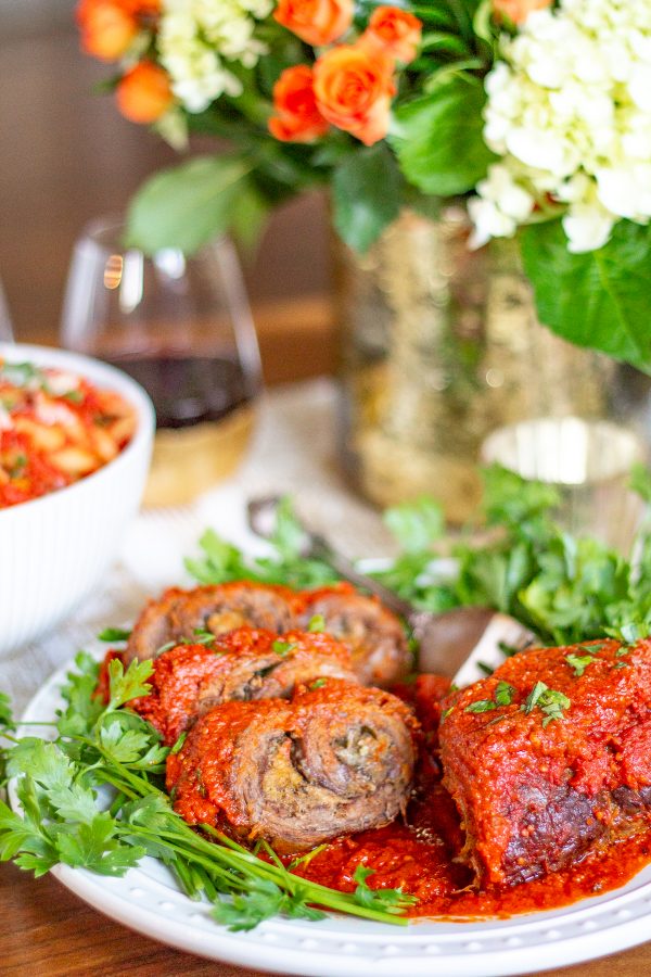 Braciole with a Tomato Sauce | Braciole is a recipe that is perfect for a special occasion that only requires 20 minutes of active preparation time. Flank Steak is topped with cheese, herbs, and breadcrumbs, seared, and then roasted in tomato sauce. Let this recipe for Braciole with tomato sauce be your secret weapon for hosting a dinner party.