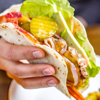Bacon Cheeseburger Tacos are made with cheeseburger wrapped in flour tortillas and topped with tomato, avocado, bacon, lettuce, pickles, grilled red onion, and a sriracha animal sauce. They are just as crazy delicious as you might imagine.