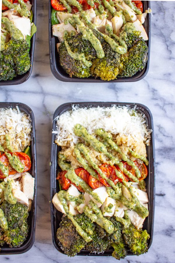 Pesto Salad Bowls are made with fresh baby spinach, quinoa, roasted tomatoes, roasted broccoli, diced chicken, parmesan, and pesto. It's a perfect recipe to meal prep.