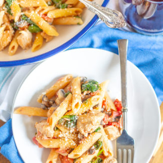 Creamy Tomato Penne with Chicken | My Creamy Tomato Penne recipe is so easy and so delicious. It is the type of meal that comes together quickly and feeds the entire family. Penne pasta is served with a creamy tomato sauce along with diced tomatoes, tender diced chicken breast, mushrooms and spinach. It is a 30 minute recipe that I make again and again.