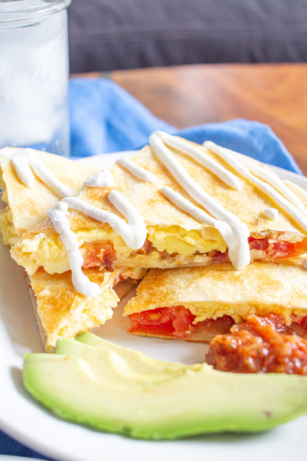 Breakfast Quesadillas have become our favorite weekend breakfast. This meal combines cheesy scrambled eggs with crispy bacon and fresh tomatoes inside crispy tortillas. Serve the quesadillas sliced into triangles with salsa, guacamole, and/or sour cream for dipping.