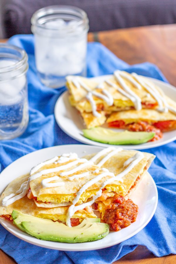 Breakfast Quesadillas have become our favorite weekend breakfast. This meal combines cheesy scrambled eggs with crispy bacon and fresh tomatoes inside crispy tortillas. Serve the quesadillas sliced into triangles with salsa, guacamole, and/or sour cream for dipping.