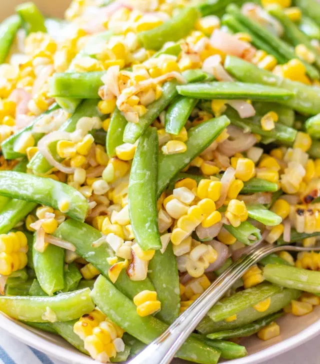 Sugar Snap Pea and Corn Salad | This Sugar Snap Pea and Corn Salad with caramelized shallots and a citrus yogurt dressing is an untraditional addition to Thanksgiving dinner that my family loves.