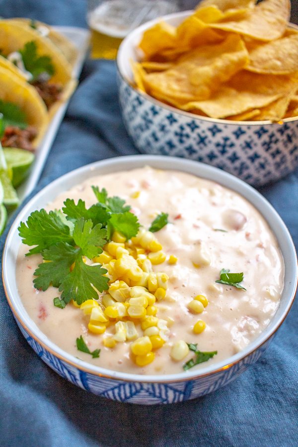 Corn Queso | This creamy cheesy corn queso is loaded with fresh steamed corn, tomatoes, and green chilies. #queso #dip