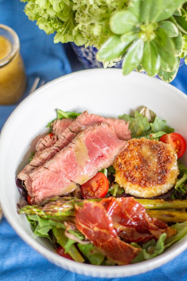 Steak and Fried Goat Cheese Salad a complete meal with greens, asparagus, tomatoes, crispy prosciutto, fried goat cheese, steak, and a light roasted garlic and mustard dressing.