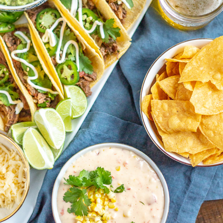 Slow Cooker Shredded Beef Tacos | Slow cooker shredded beef tacos are made with corn tortillas filled with tender spicy shredded beef and topped with cheese, jalapenos, cilantro, and sour cream. This is a zero fuss meal that can feed the whole family with only minutes of active preparation time. #tacos #beef