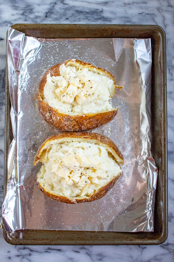 Twice Baked Brie Potatoes are baked potatoes with crispy salty skins that are filled with creamy mashed potatoes made with brie, sour cream, garlic, and parmesan.