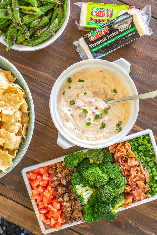 How to Make Queso | Your friends and family will love this easy game-day queso recipe and queso bar ideas! Warm melted queso made with @cabotcheese is delicious over chips, baked potatoes, tacos, and hot dogs. This recipe is a great addition to any party!