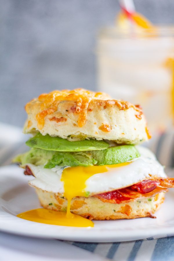 The Best Breakfast Sandwich | This meal is a way to get your day off to a great start. This breakfast sandwich is made with a fried egg, bacon, and avocado on a homemade cheddar cheese and green onion biscuit. The finishing touch is a drizzle of ranch dressing.