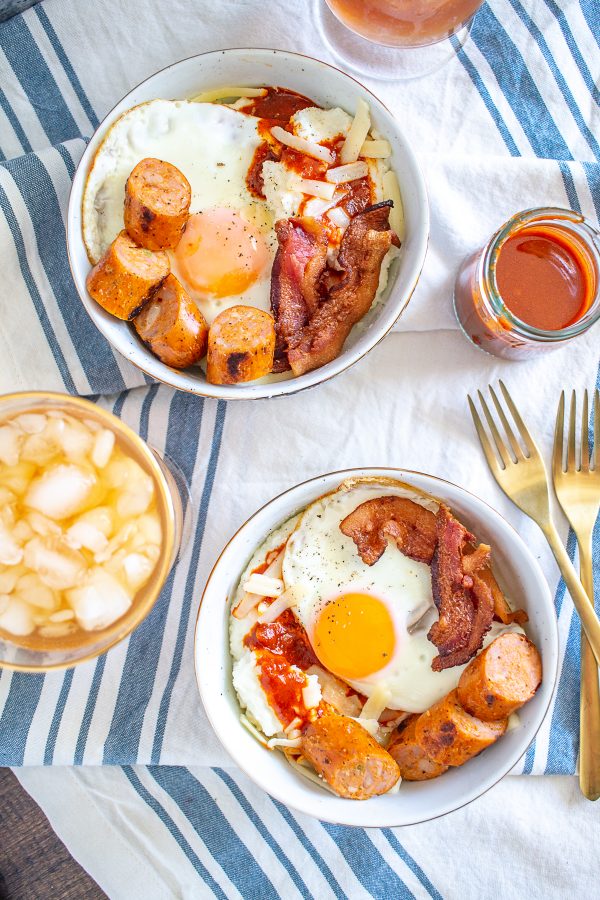 Grits Breakfast Bowl | Creamy cheddar grits are topped with an egg, bacon, sausage, and red chile sauce
