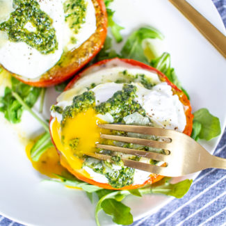 Caprese Eggs Benedict is an easy to make twist on traditional Eggs Benedict made with roasted tomatos, mozzarella, pesto, and poached eggs. It's one of my favorite breakfasts to make at home over the weekend.