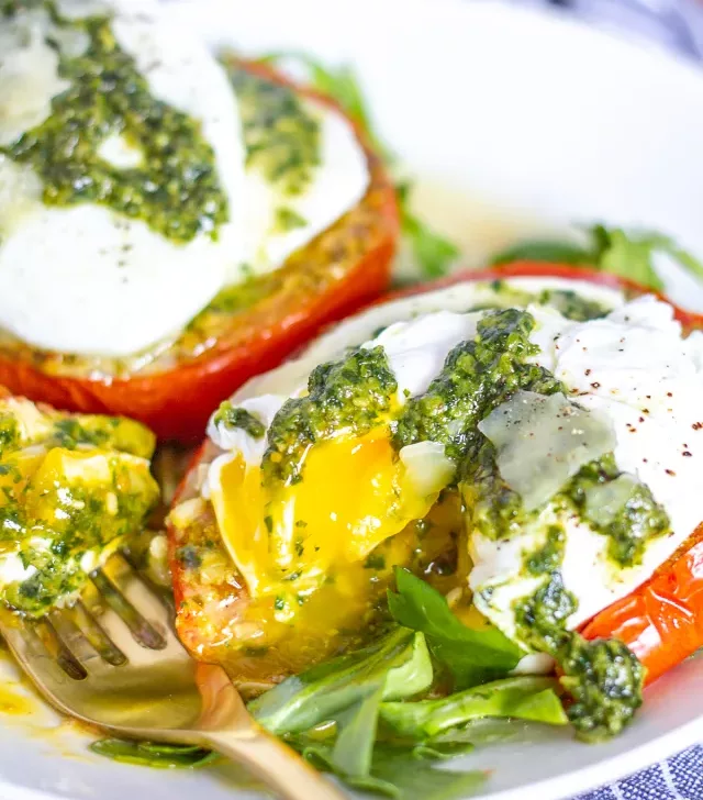 Caprese Eggs Benedict is an easy to make twist on traditional Eggs Benedict made with roasted tomatos, mozzarella, pesto, and poached eggs. It's one of my favorite breakfasts to make at home over the weekend.